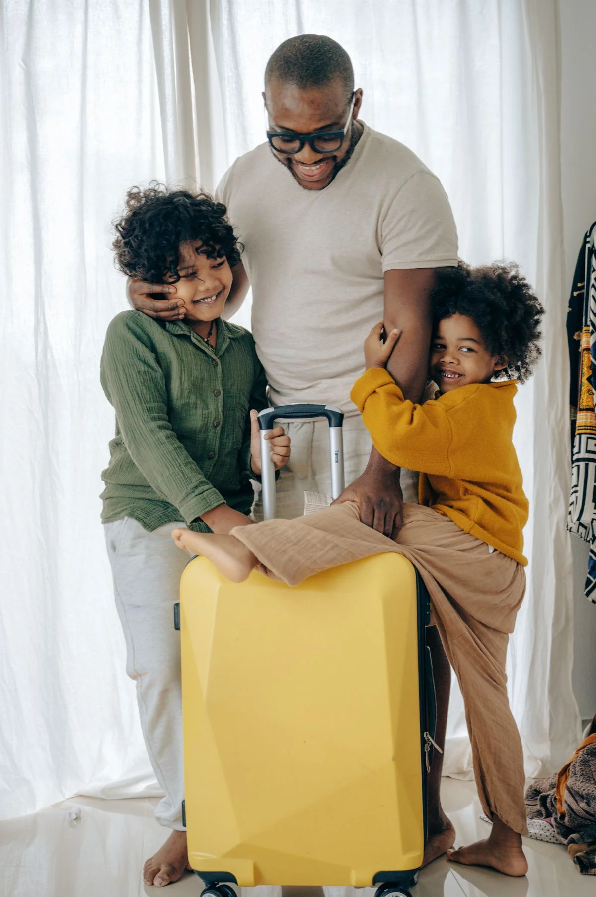A father and children preparing for a trip with their suitcase