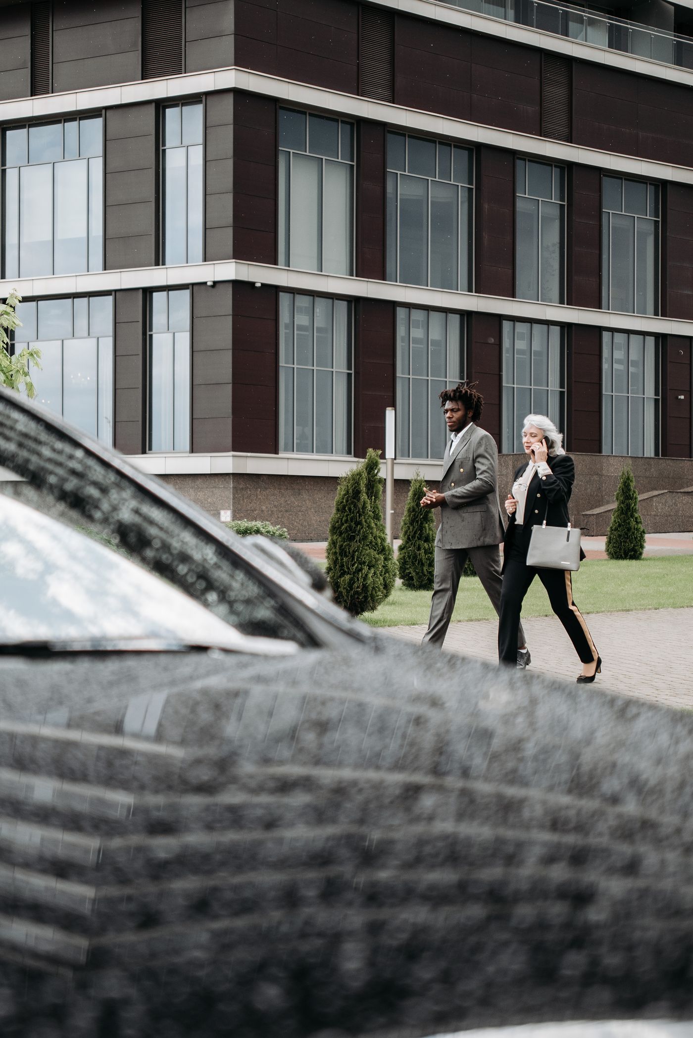 Two business travellers walking towards a car